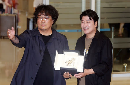 South Korean director Bong Joon-ho and actor Song Kang-ho pose with Palme d'Or prize of the Cannes Film Festival as they arrive at Incheon International Airport in Incheon, South Korea, May 27, 2019. Picture taken May 27, 2019. Yonhap/via REUTERS