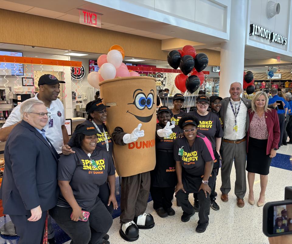 Cuppy, the Dunkin' mascot, poses for photos at the grand opening of new eatery options in the Wilmington International Airport on April 18, 2024.