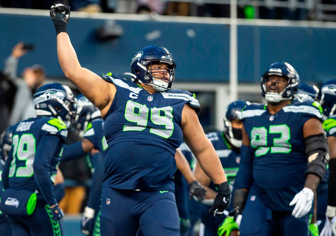 Seattle Seahawks defensive tackle Al Woods (99) celebrates after Seattle Seahawks safety Quandre Diggs (6) intercepted a pass in overtime of an NFL game against the Los Angeles Rams at Lumen Field in Seattle, Wash. on Jan. 8, 2023. The Seahawks defeated the Rams in overtime 19-16.