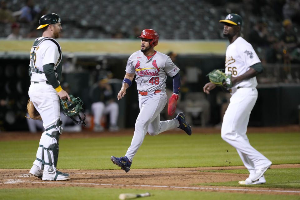 St. Louis Cardinals' Iván Herrera (48) scores a run past Oakland Athletics pitcher Dany Jiménez (56) and catcher Kyle McCann, left, on a sacrifice fly by Jordan Walker during the sixth inning of a baseball game in Oakland, Calif., Tuesday, April 16, 2024. (AP Photo/Tony Avelar)