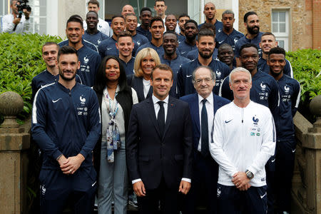 FILE PHOTO: French President Emmanuel Macron (C) and his wife, Brigitte Macron, pose for a group photo with the French national soccer team upon their arrival for lunch at France's training camp in Clairefontaine, near Paris, France, June 5, 2018 prior to the national team's participation to the 2018 FIFA World Cup Russia. Francois Mori/Pool via Reuters/File Photo