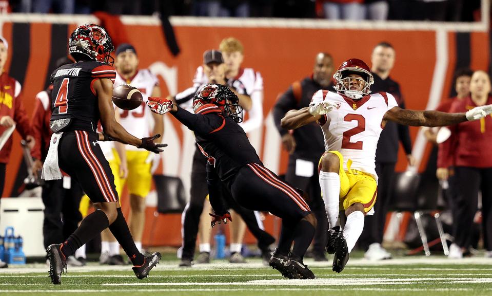 Utah Utes cornerback JaTravis Broughton (4) catches the the deflected ball as Utah Utes cornerback Clark Phillips III (1) gets called for pass interference on USC Trojans wide receiver Brenden Rice (2) as Utah and USC play at Rice Eccles Stadium in Salt Lake City on Saturday, Oct. 15, 2022. Utah won 43-42. | Scott G Winterton, Deseret News