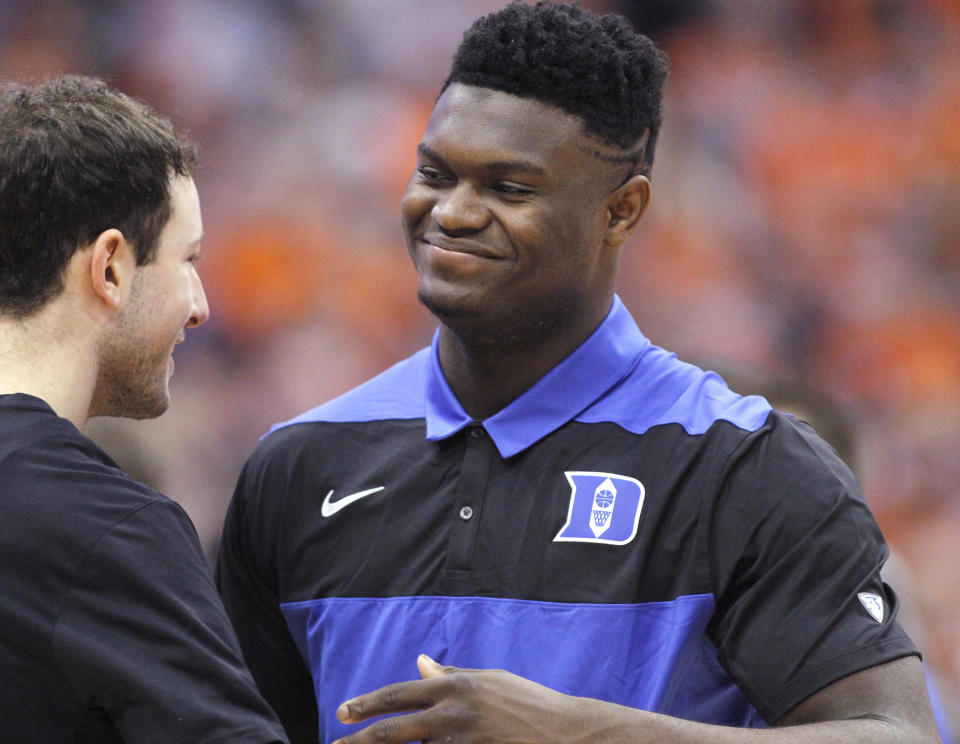 Duke's Zion Williamson, right, is greeted by a teammate on the court before the team's NCAA college basketball game against Syracuse in Syracuse, N.Y., Saturday, Feb. 23, 2019. (AP Photo/Nick Lisi)