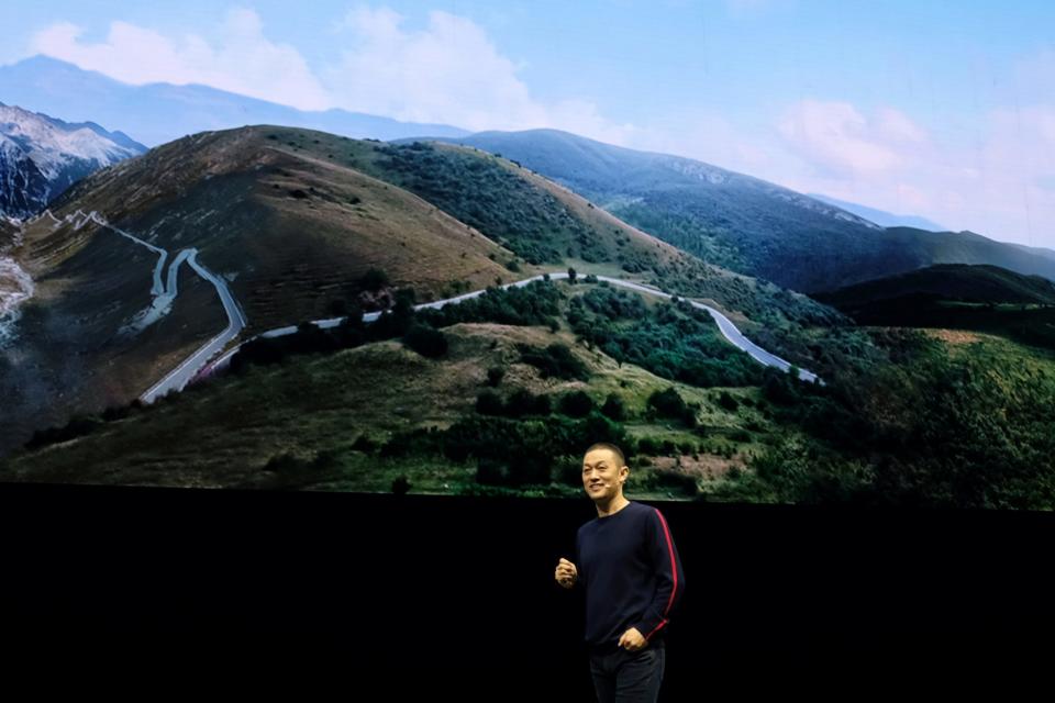 William Li onstage in front of an image of the countryside