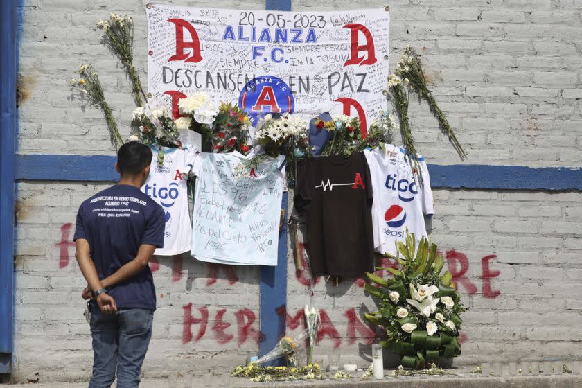 Un aficionado del Alianza se ve parado ante las ofrendas