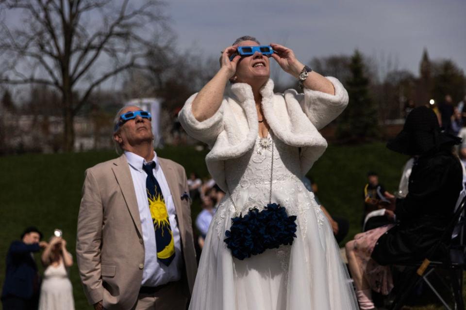 A bride and groom watch the solar eclipse