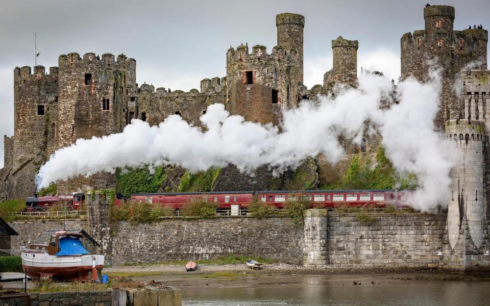 The locomotive Galatea steams past Conwy Castle, built in the late 13th century - alamy