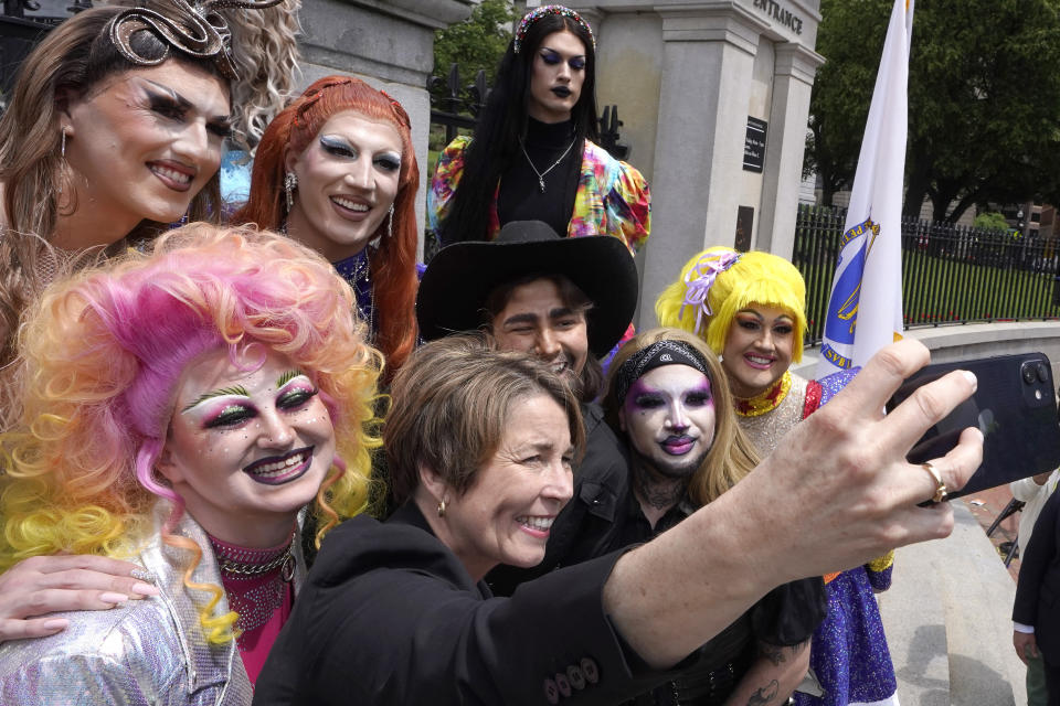 Massachusetts Gov. Maura Healey, below center, takes a selfie with drag performers, including MT Hart, below left, and Zayn X, below center right, during a Pride Month Celebration, Wednesday, June 7, 2023, on the steps of the Statehouse, in Boston. Healey said Massachusetts is a state that "prizes equality, protects freedoms, protects civil rights, protects the LGBTQ community, and that would be a broader message to people nationally." (AP Photo/Steven Senne)