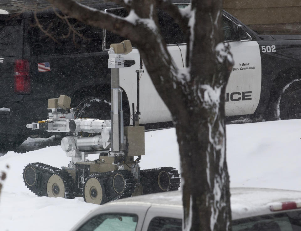A robot is used as authorities respond to the scene of a shooting on Oakland Avenue South, Sunday, Dec. 1, 2019, in Minneapolis. Two boys were found shot late Sunday morning outside the residence, where two adults were found dead later in the day. The two boys were also later pronounced dead, in what police are calling a "domestic related incident." (Kevin Martin/Star Tribune via AP)