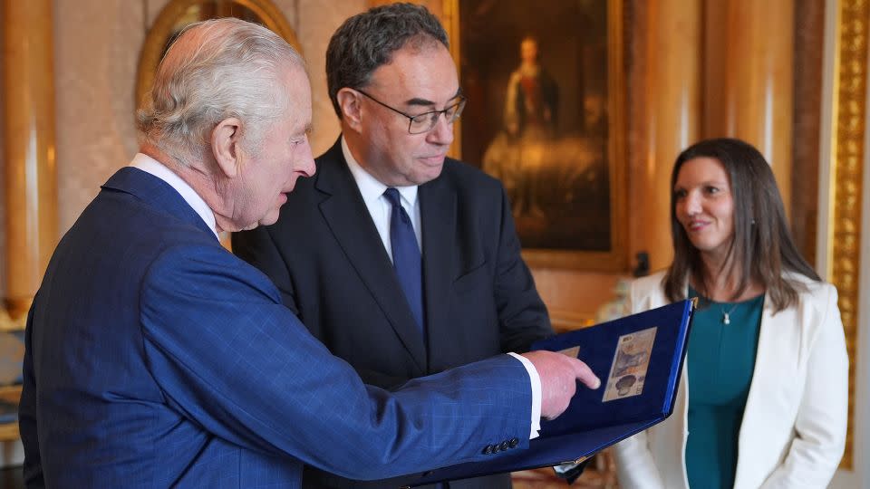 The King is presented with the first bank notes featuring his portrait by Bank of England Governor Andrew Bailey and Chief Cashier Sarah John. - Yui Mok/POOL/AFP/Getty Images