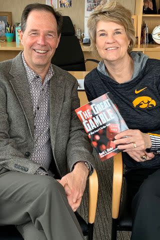 <p>twitter.com/LisaBluder</p> Lisa Bluder and her husband, David, pose with his book "The Great Gamble."