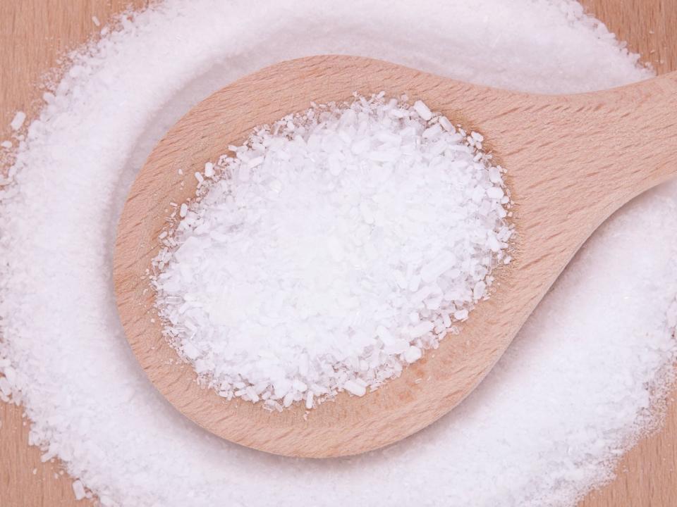 Epsom salt, a tool that can help kill unwanted tree stumps, in a wooden spoon. 