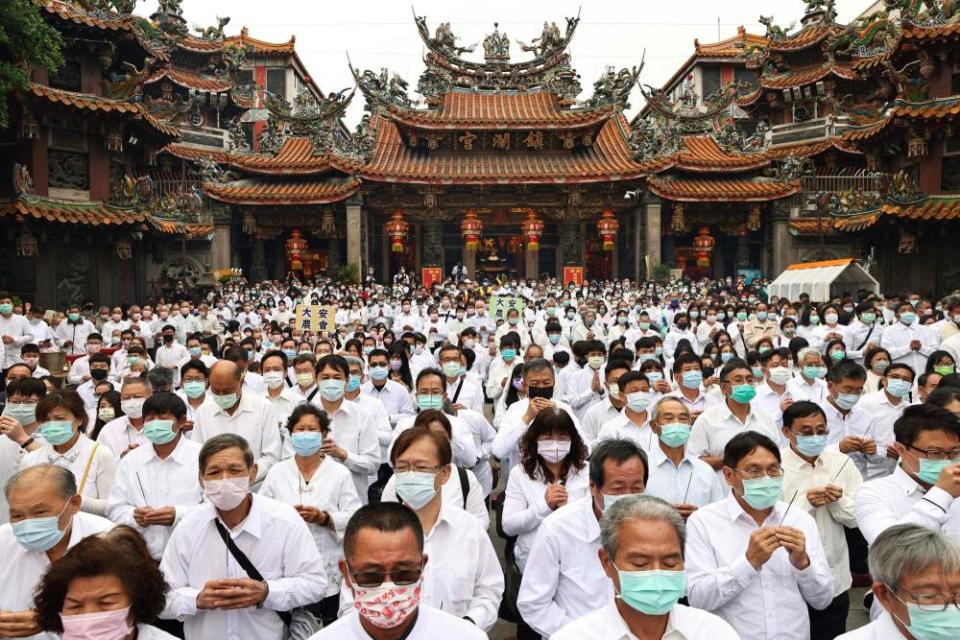 People holding joss sticks pray to the sea goddess Mazu to wish for rain during a religious ceremony in Taichung.