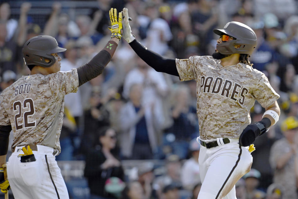 San Diego Padres' Juan Soto, left, celebrates with Fernando Tatis Jr. after Tatis scores on a double by Manny Machado against the Los Angeles Dodgers during the first inning of a baseball game in San Diego, Sunday, May 7, 2023. (AP Photo/Alex Gallardo)