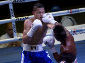 U.S. boxer Luis Arcon punches Cuban boxer Lazaro Álvarez, left, during their men's 60 kg boxing match in Havana, Cuba, Friday, April. 4, 2014. Boxers from the U.S. and Cuba went glove-to-glove on Cuban soil for the first time in 27 years Friday in a semipro World Series of Boxing clash (AP Photo/Ramon Espinosa)