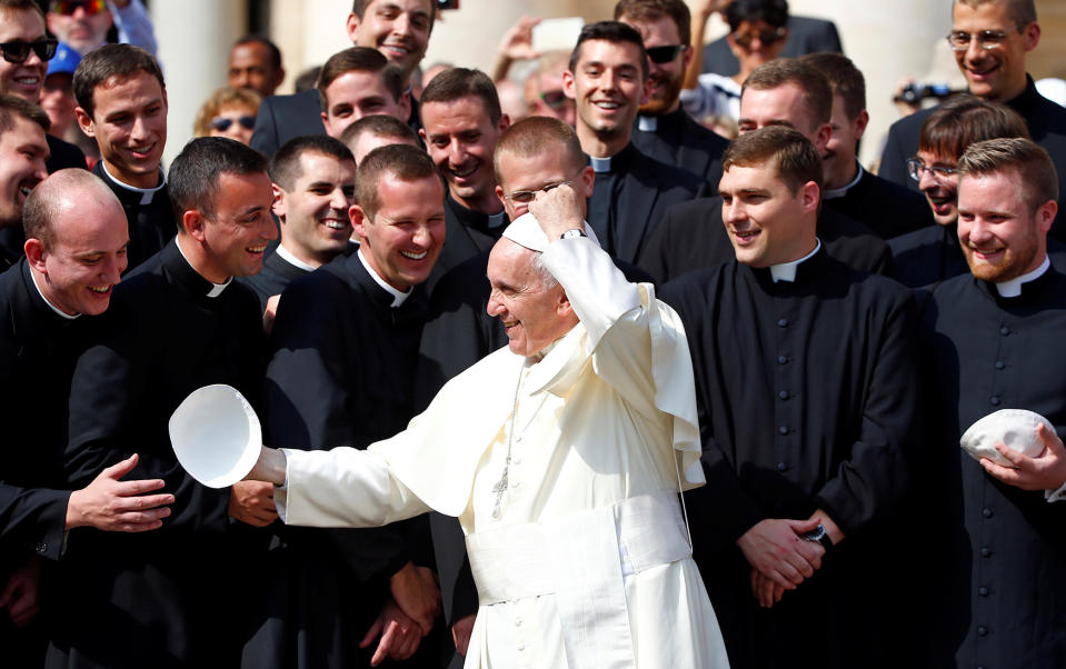 <p>Pope Francis exchanges his skullcap as he poses with a group of priests during the weekly audience in Saint Peter’s Square at the Vatican Sept. 28, 2016. (Photo: Remo Casilli/Reuters) </p>