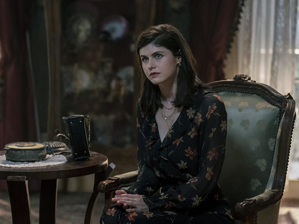 Alexandra Daddario sitting down next to a small table in AMC's "Mayfair Witches"