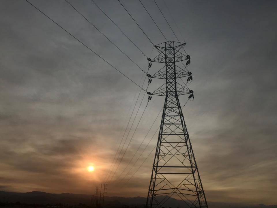 The sun begins to set behind an energy power pole near Coachella on Wednesday, Sept. 9, 2020