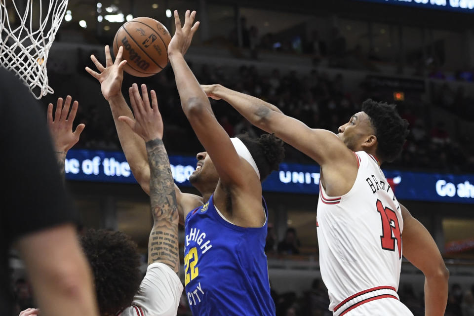 Denver Nuggets forward Zeke Nnaji (22) drives to the basket against Chicago Bulls guard Lonzo Ball, left, and center Tony Bradley, right, during the first half of an NBA basketball game Monday, Dec. 6, 2021, in Chicago. (AP Photo/Matt Marton)