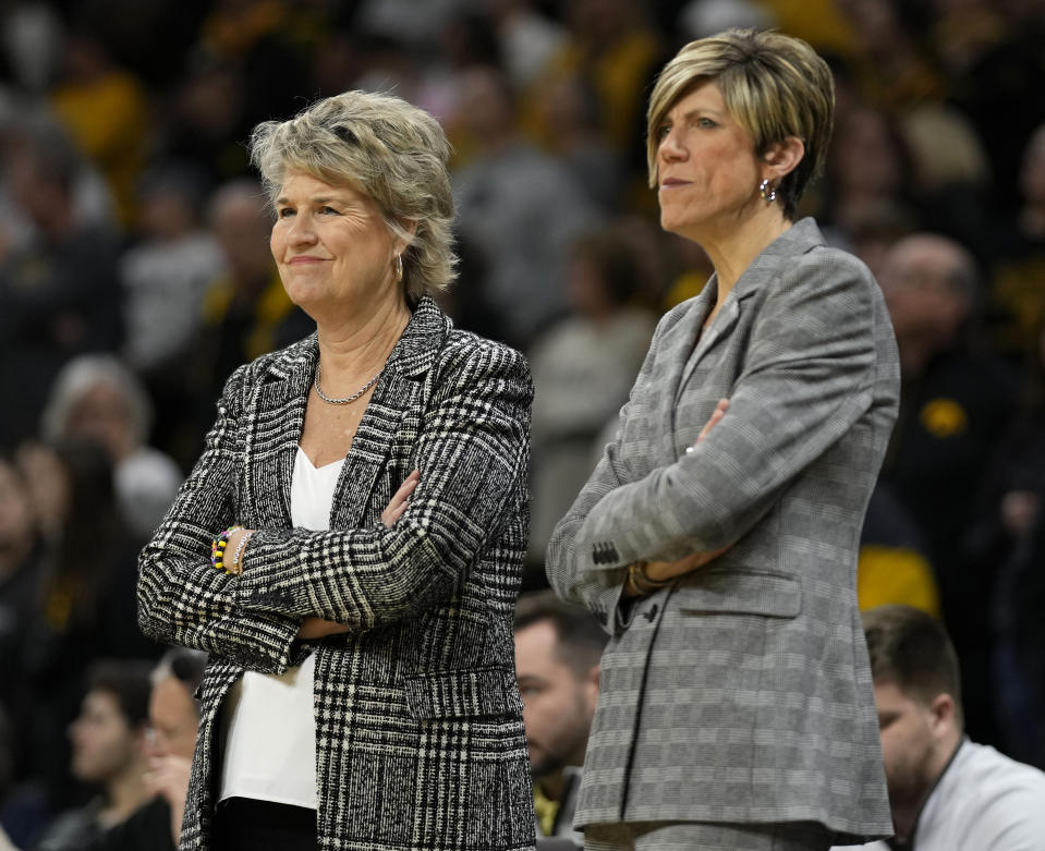 FILE - Iowa head coach Lisa Bluder, left, stands with associate head coach Jan Jensen, right, before an NCAA college basketball game against Nebraska, Saturday, Jan. 27, 2024, in Iowa City, Iowa. Bluder announced Monday, May 13, 2024, she is retiring after leading the Hawkeyes for 24 seasons. Jensen, longtime assistant to Bluder, was named the new head coach of the Iowa women's basketball team. (AP Photo/Charlie Neibergall, File)