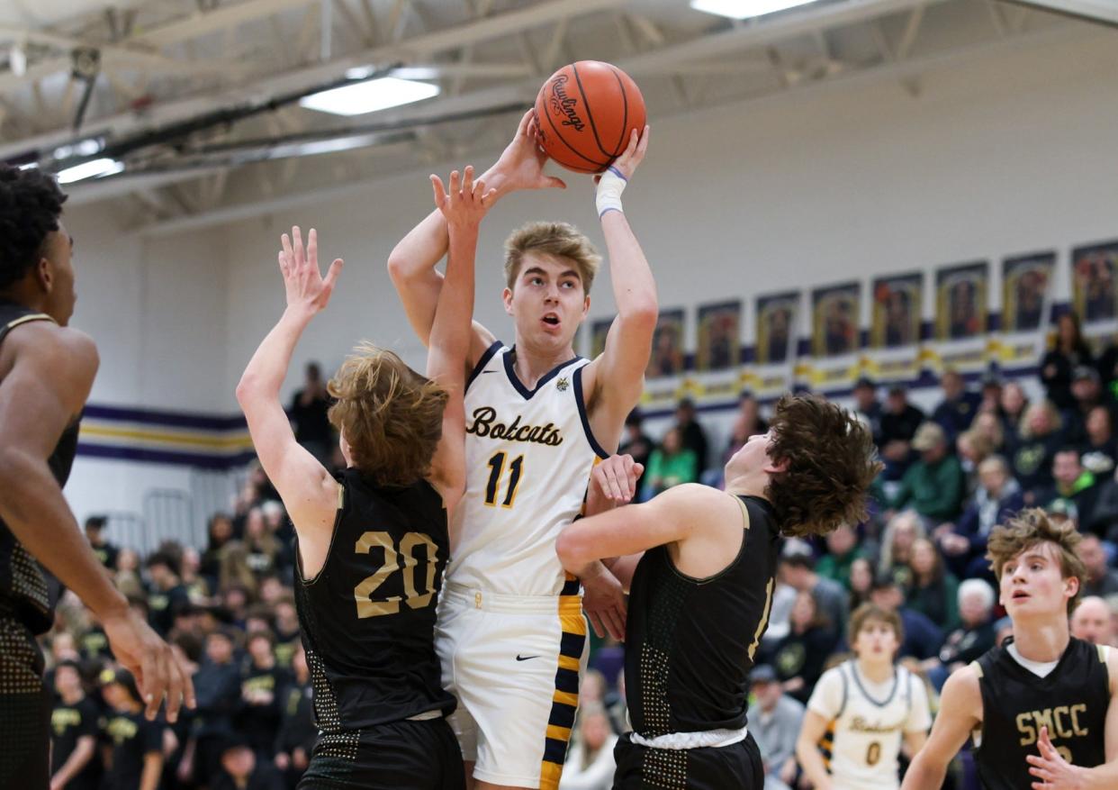 Whiteford's Evan Parker rises over Trent Zachel and Brady Hines of St. Mary Catholic Central Friday night. Whiteford beat SMCC 62-52 in the finals of the Division 3 District at Blissfield.
