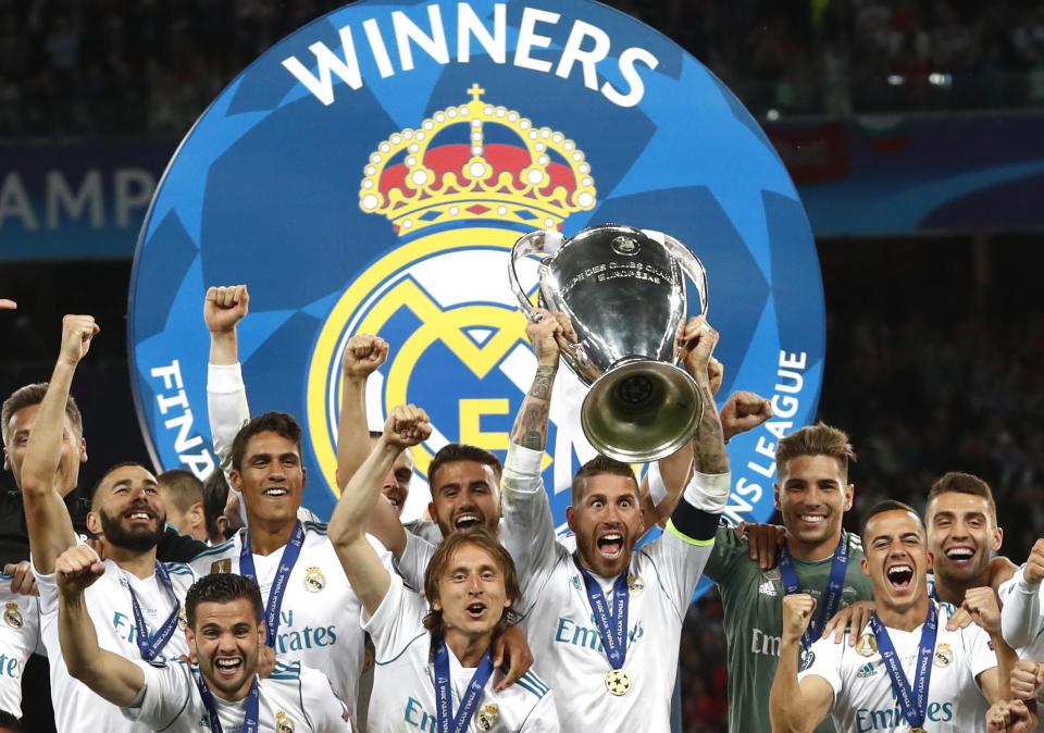 FILE - In this Saturday, May 26, 2018 file photo Real Madrid players celebrate with the trophy after winning the Champions League Final soccer match between Real Madrid and Liverpool at the Olimpiyskiy Stadium in Kiev, Ukraine. T is for Thirteen. Kiev 2018 was Real Madrid's thirteenth triumph in Europe's top soccer competition and makes them clearly the most successful team in the event's history. (AP Photo/Matthias Schrader, File)