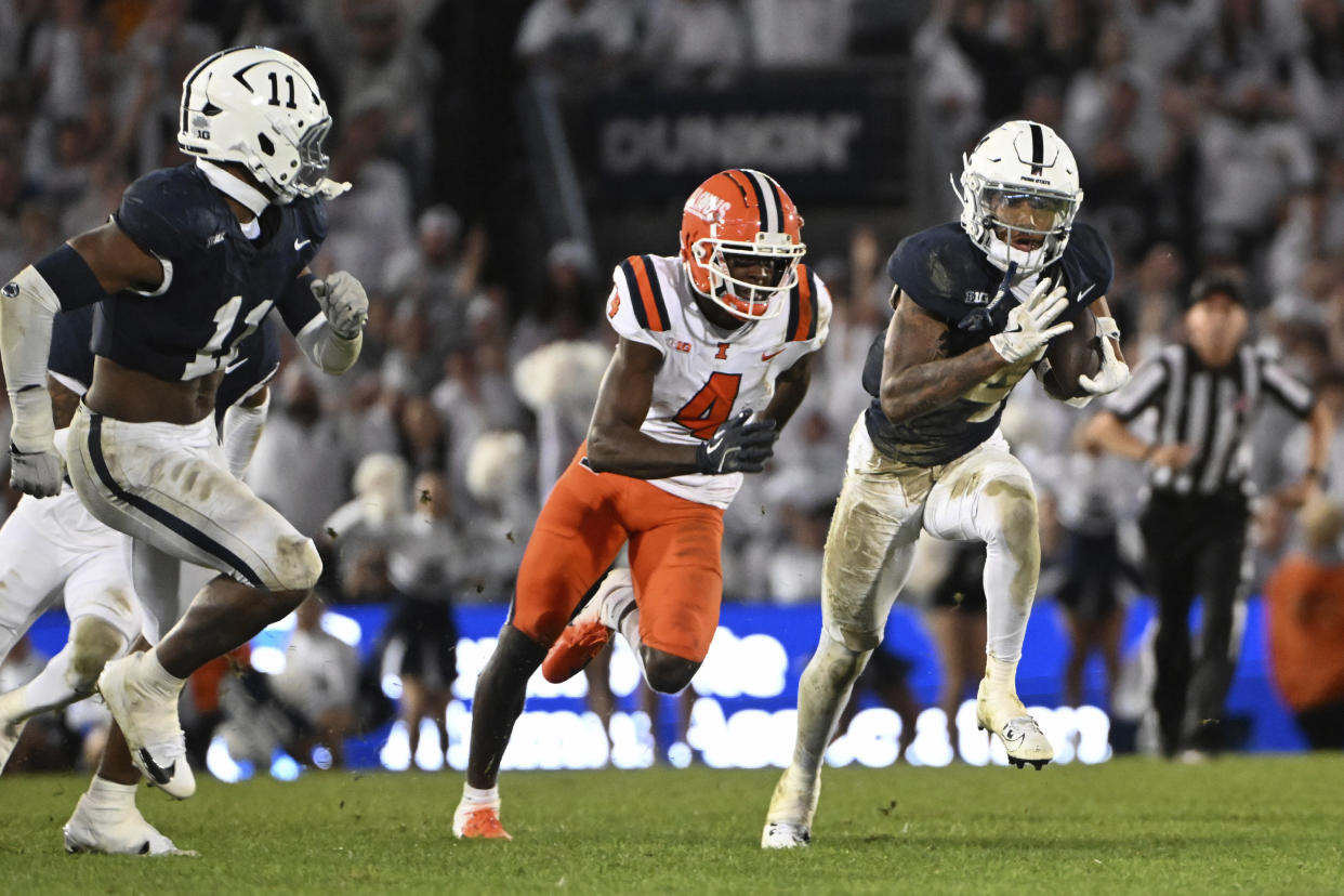 Penn State cornerback A.J. Harris, right, returns an interception while pursued by Illinois wide receiver Zakhari Franklin, center, during the fourth quarter of an NCAA college football game, Saturday, Sept. 28, 2024, in State College, Pa. (AP Photo/Barry Reeger)