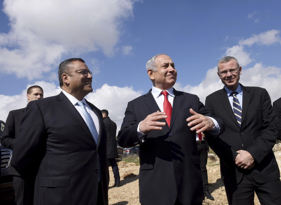 Israeli Prime Minister Benjamin Netanyahu, center, stands with Jerusalem Mayor Moshe Leon, left, as he announces a new neighborhood is to be built in the Israeli West Bank Israeli settlement of Har Homa, Thursday, Feb. 20, 2020. (Debbie Hill/Pool via AP)