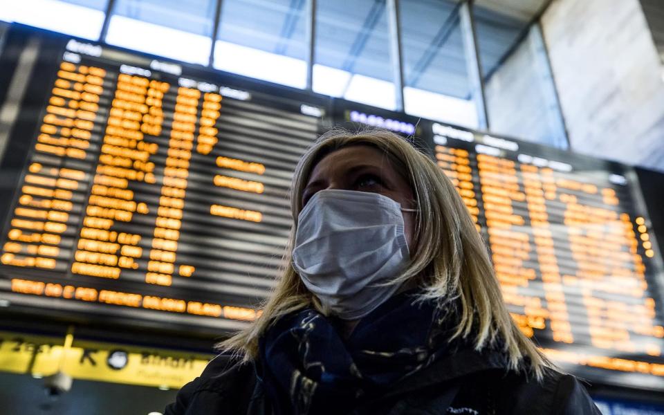  A woman wearing a protective mask walks at the Termini Station in Rome, Italy