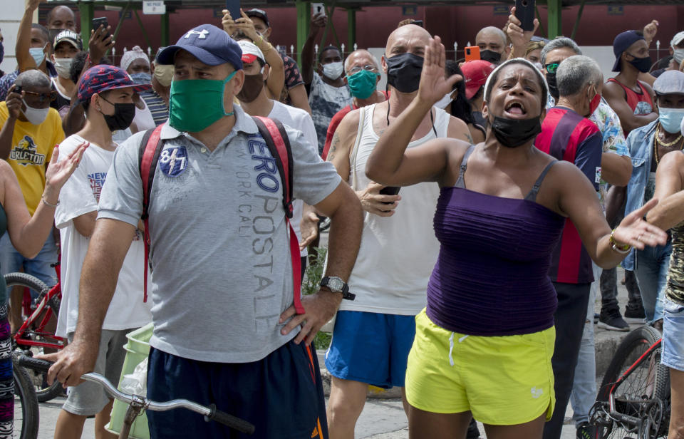 A woman shouts during a an anti-government protest in Havana, Cuba, Sunday, July 11, 2021. Hundreds of demonstrators went out to the streets in several cities in Cuba to protest against ongoing food shortages and high prices of foodstuffs. (AP Photo/Ismael Francisco)