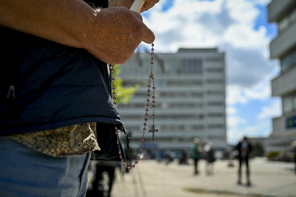 A man prays holding Slovakia's flag outside the F. D. Roosevelt University Hospital, where Slovak Prime Minister Robert Fico, who was shot and injured, is treated in Banska Bystrica, central Slovakia, Thursday, May 16, 2024. Slovakia's populist Prime Minister Robert Fico was shot multiple times and gravely wounded Wednesday, but his deputy prime minister said he believed Fico would survive. (AP Photo/Denes Erdos)