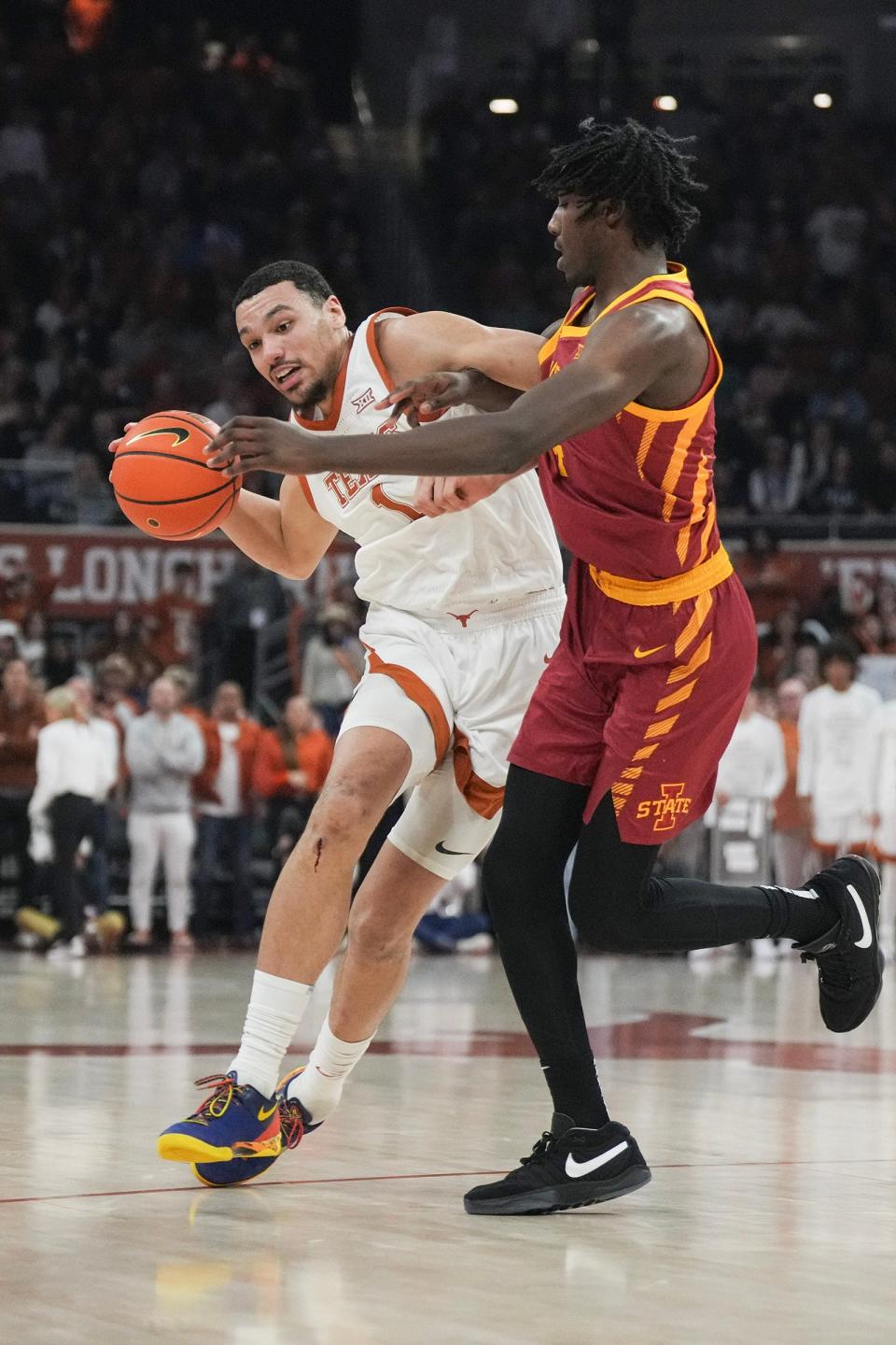 Texas forward Dylan Disu, left, drives toward the basket against Iowa State guard Demarion Watson in Tuesday's Big 12 game at Moody Center. Iowa State held on for a 70-65 win despite 28 points from Disu.