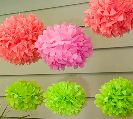 Photo by: Sybill Holland via On To Baby<br><br><b>Neon tissue poms</b> <br> You can buy these or make them yourself! Neon poms made of brightly colored tissue paper are a simple and visually striking decor idea. They'd look great hanging from trees outside or the ceiling, and could also be used to make a beautiful centerpiece. <br> <b><i><a rel="nofollow noopener" href="http://www.disneybaby.com/blog/baby-girl-shower-cupcakes/" target="_blank" data-ylk="slk:Related: 15 Disney-inspired cupcakes for your next party;elm:context_link;itc:0;sec:content-canvas" class="link ">Related: 15 Disney-inspired cupcakes for your next party</a></i></b>