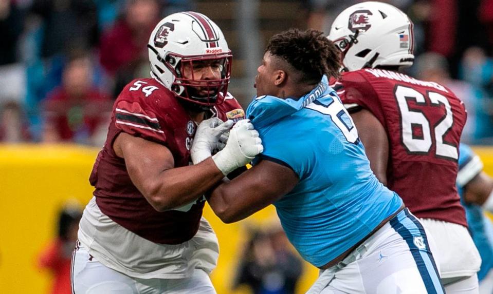 North Carolina defensive lineman Myles Murphy (8) tangles with South Carolina’s Jovaughn Gwyn (54) after loosing his helmet the Gamecocks’ 38-21 victory during the Duke’s Mayo Bowl at Bank of America Stadium in December 2021.