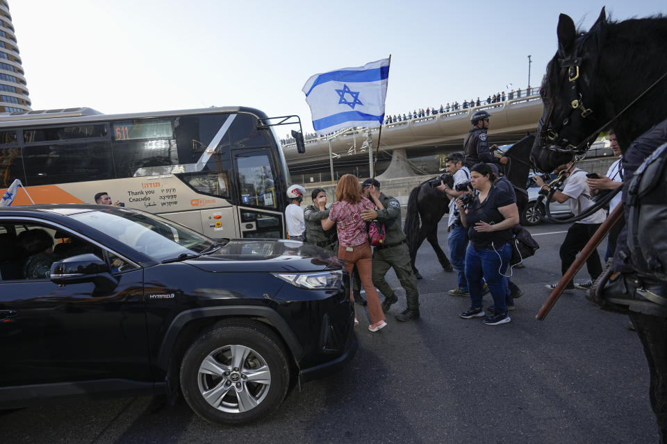 Israeli police scuffle with protesters as they try to block a main road to protest against plans by Prime Minister Benjamin Netanyahu's new government to overhaul the judicial system, in Tel Aviv, Israel, Wednesday, March 1, 2023. (AP Photo/Ohad Zwigenberg)