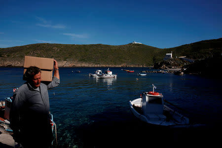 A local carries medical supplies as volunteer doctors of the Aegean Team arrive to visit patients on the islet of Thymaina, Greece, May 11, 2017. REUTERS/Alkis Konstantinidis