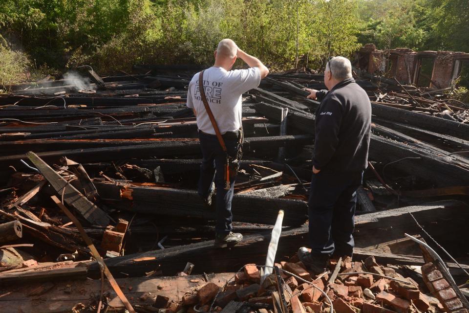 Norwich Fire Lt. Glenn Watts, left, and Deputy Fire Marshal Captain Mark Gilot investigate the former Capehart Mill fire aftermath Thursday morning in the Greeneville section of Norwich.