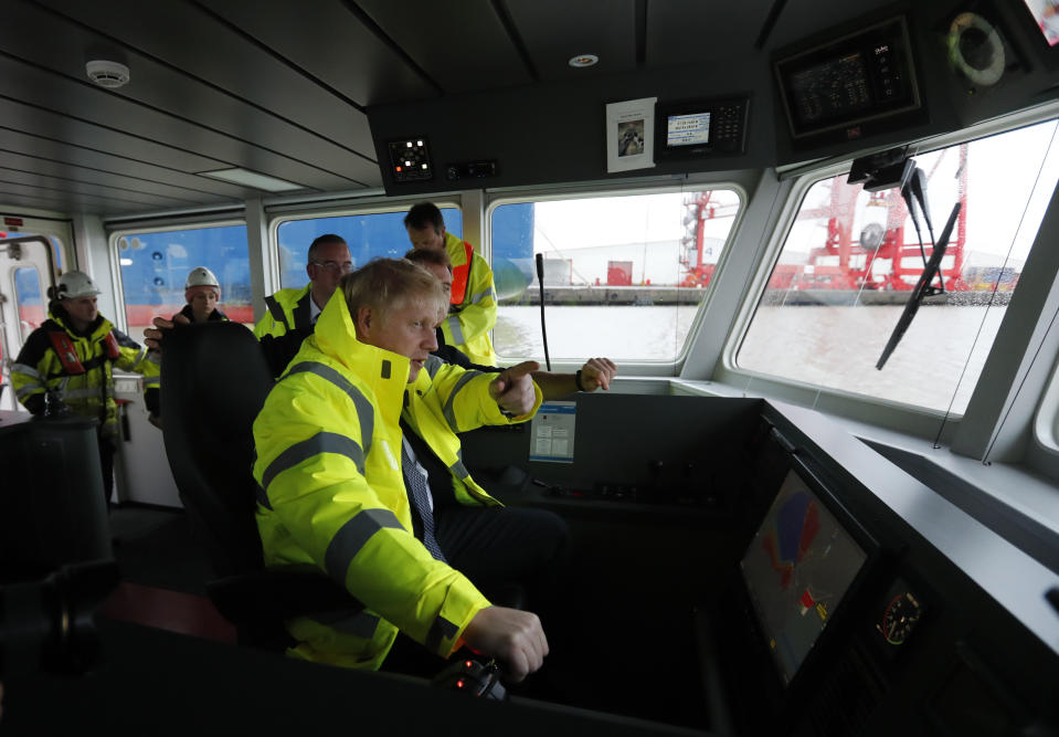 Britain's Prime Minister Boris Johnson steers a tug boat during a General Election campaign stop in the port of Bristol, England, Thursday, Nov. 14, 2019. Britain goes to the polls on Dec. 12. (AP Photo/Frank Augstein, Pool)