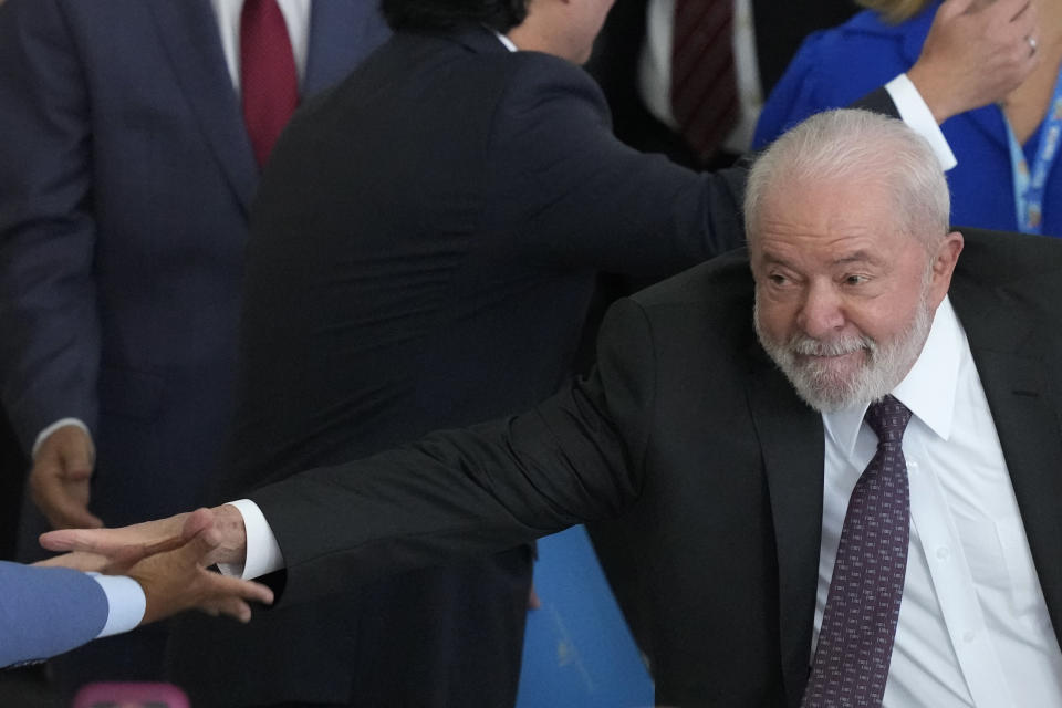 Brazil's President Luiz Inacio Lula da Silva reaches out to shake someone's hand as he arrives for a ceremony to relaunch the Bolsa Familia or Family Grant program, at the Planalto Palace, in Brasilia, Brazil, Thursday, March 2, 2023. Bolsa Familia is a cash transfer program that aims to help families living in poverty. (AP Photo/Eraldo Peres)