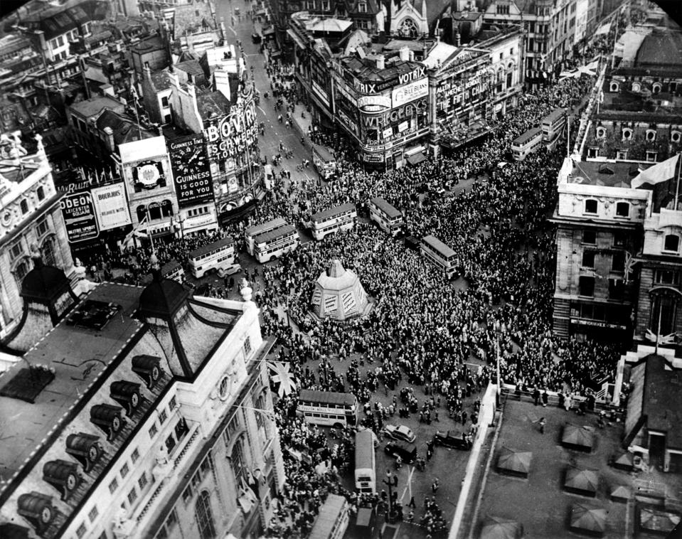 FILE - In this May 8, 1945 file photo a crowd gathers to celebrate VE Day in Piccadilly Circus in London, England. On Friday's 75th anniversary of the end of World War II in Europe, talk of war is afoot again — this time against a disease that has killed at least a quarter of a million people worldwide. Instead of parades, remembrances and one last great hurrah for veterans now mostly in their nineties, it is a time of lockdown and loneliness, with memories bitter and sweet (AP Photo, File)