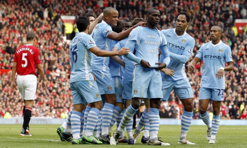 Mario Balotelli celebrates scoring the opening goal in the Manchester derby.