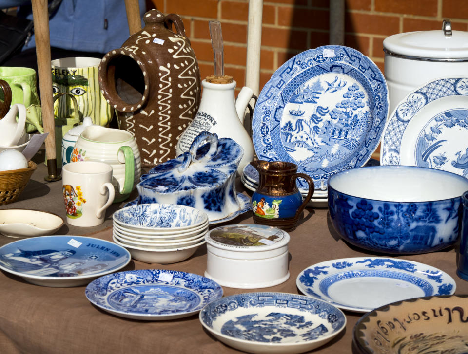 Fakenham, Norfolk, England - September 24, 2015: A market stall selling old china. There is a variety of ages, types and styles including plates, jugs, mugs, dishes, bowls and an inhaler, seen on a bright and sunny early autumn day.