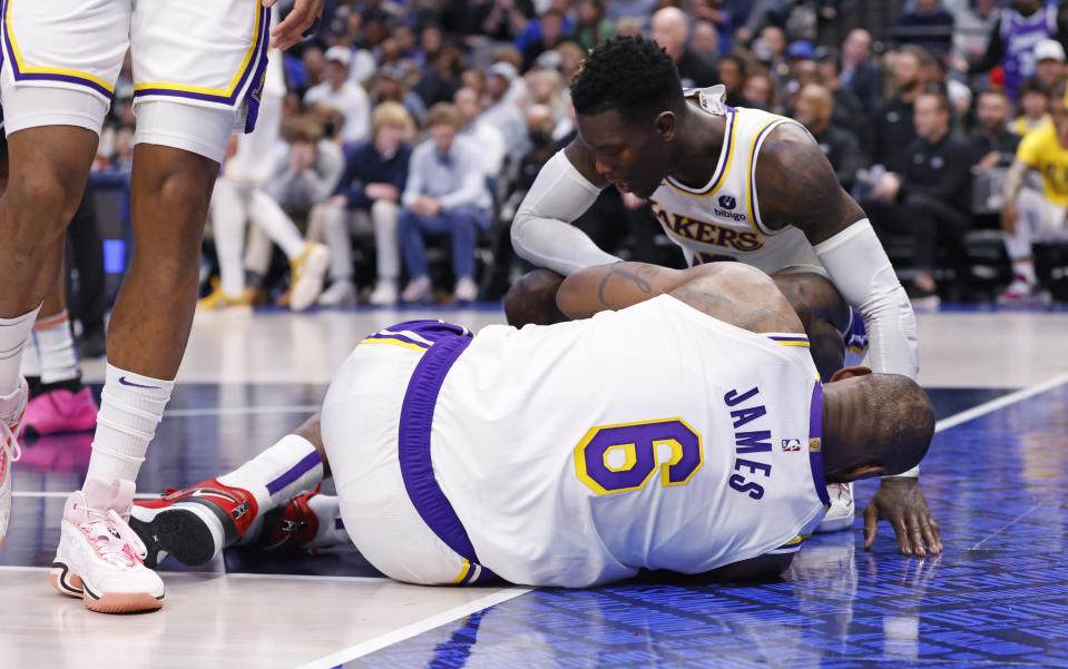 DALLAS, TX - FEBRUARY 26 :  LeBron James #6 of the Los Angeles Lakers reacts after injuring his ankle against the Dallas Mavericks as teammate Dennis Schroder #17 check s on him at American Airlines Center on February 26, 2023 in Dallas, Texas. NOTE TO USER: User expressly acknowledges and agrees that, by downloading and or using this photograph, User is consenting to the terms and conditions of the Getty Images License Agreement. (Photo by Ron Jenkins/Getty Images)