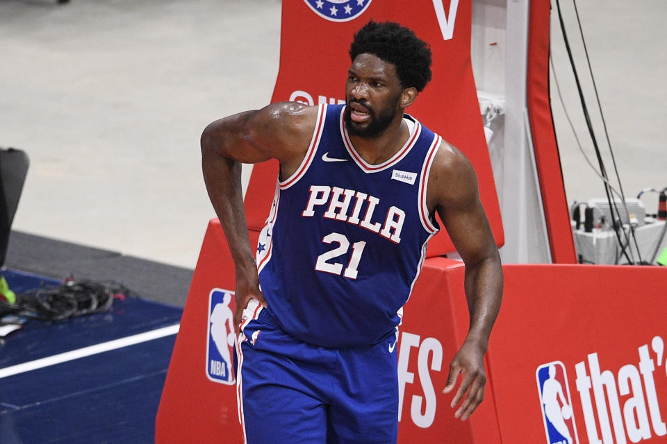 Philadelphia 76ers center Joel Embiid (21) touches his right side after he fell on the court during the first half of Game 4 in a first-round NBA basketball playoff series against the Washington Wizards, Monday, May 31, 2021, in Washington. (AP Photo/Nick Wass)