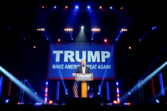 Donald Trump addresses a crowd from behind a podium at a rally.