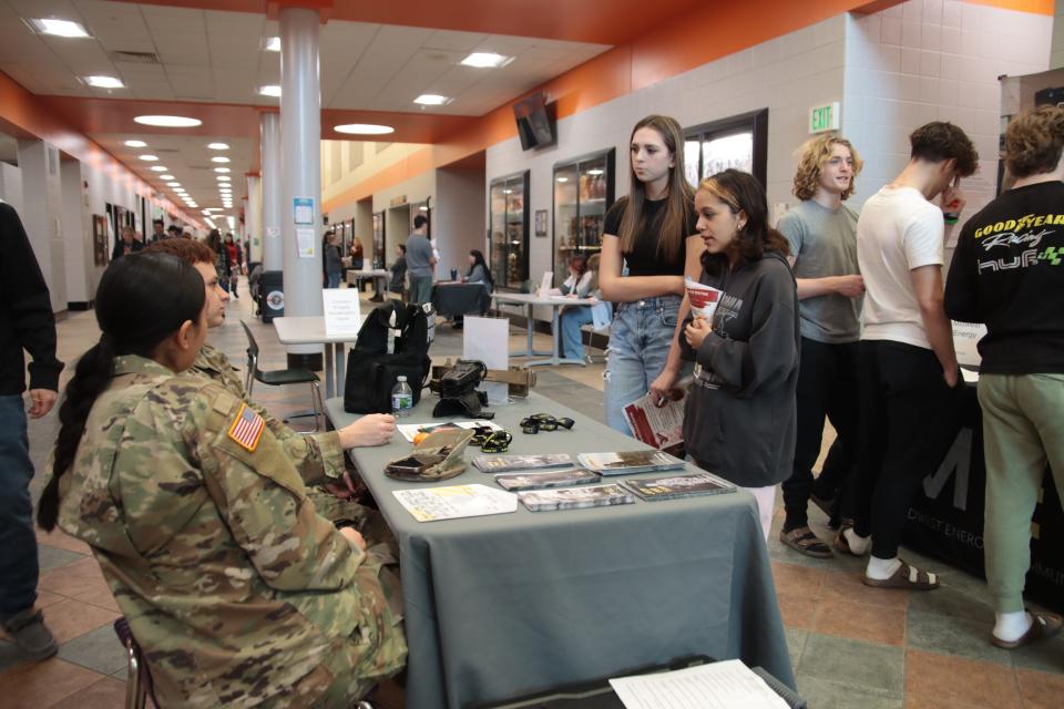 Tecumseh High School sophomores Kaitlyn Bennett and Celena Martinez talk with Spc. Heather Chacon and Sgt. Dylan Frazier of the Michigan Army National Guard during the Career Exploration Fair Wednesday at the school.