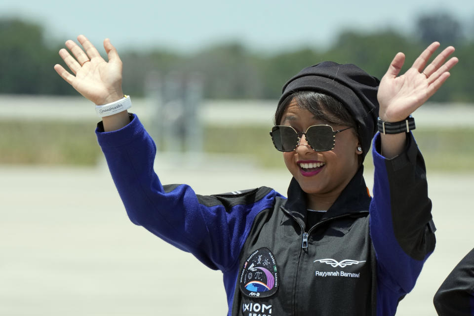 Saudi Arabian astronaut Rayyanah Barnawi waves to family and friends as she arrives at the Kennedy Space Center in Cape Canaveral, Fla., for a scheduled launch Sunday, May 21, 2023. (AP Photo/John Raoux)
