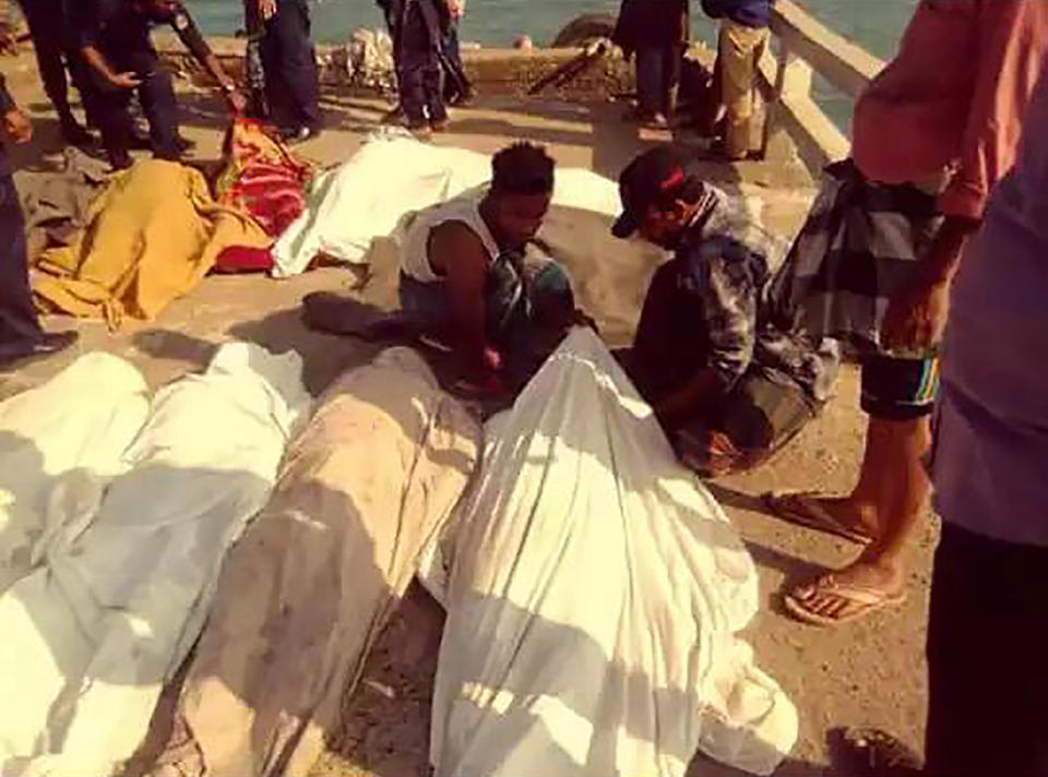 Rescuers cover the bodies of victims of a boat capsize at St. Martin's Island, Bangladesh, Tuesday, Feb. 11, 2010. An overcrowded boat carrying about 125 Rohingya refugees from Bangladeshi camps sank early Tuesday in the Bay of Bengal, leaving at least 16 dead, Bangladeshi officials said Tuesday. The coast guard, navy divers and other rescuers recovered the bodies of more than a dozen people after the wooden boat capsized off St. Martin's Island, the top elected official on the island told The Associated Press. (Joynal Abedin via AP)