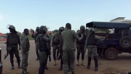 Riot police gather near a main road blocked by protesters in Sonfonia District in Conakry