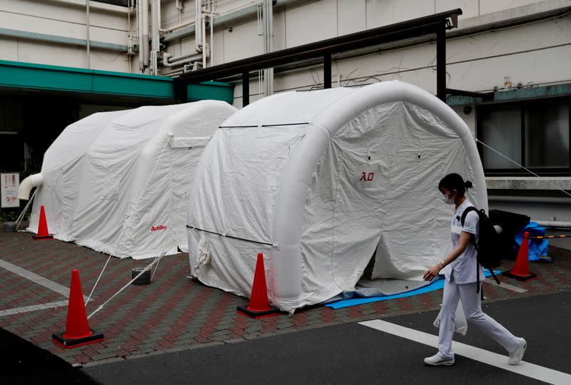 A medical worker walks by tents set up to test for the coronavirus disease (COVID-19) infection at Kawakita General Hospital in Tokyo